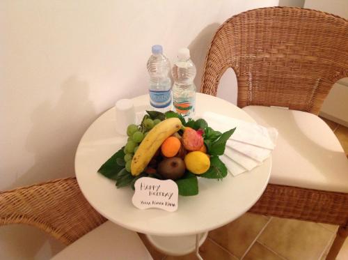a plate of fruit on a table with bottles of water at B&B Villa Nonna Maria in Castellana Grotte