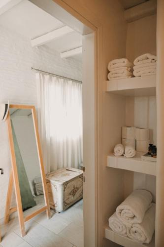 a room with a mirror and towels on shelves at Dinora Stone Villa, Pool & Sea Views in Tinos in Agios Ioannis