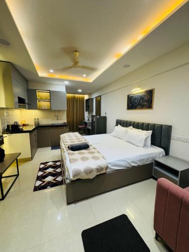 a bedroom with a large bed and a kitchen at Candlewick Homestays in Jaipur