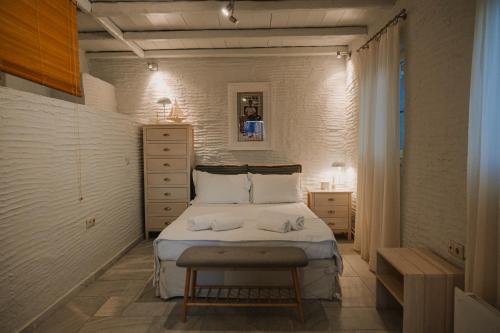 a small bedroom with a bed and a table at Dinora Stone Villa, Pool & Sea Views in Tinos in Agios Ioannis