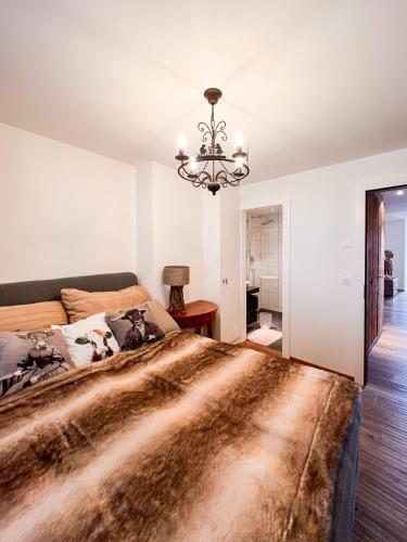 a bedroom with a large bed and a chandelier at Evasion Alpine in Crans-Montana
