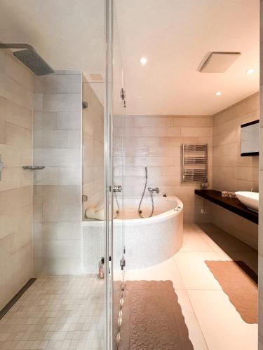 a bathroom with a bath tub and a sink at Evasion Alpine in Crans-Montana