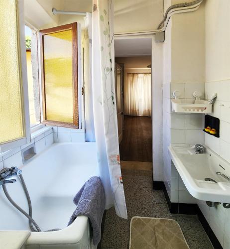 a white bathroom with a tub and a sink at Villa Coccodrilla Varallese in Varallo