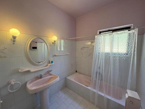 a bathroom with a sink and a tub and a mirror at Christina's Apartments in Vathi