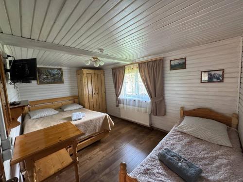 a bedroom with two beds and a wooden floor at Sadyba Geredzhuka in Vorokhta