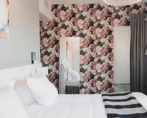a bedroom with a floral patterned wall at Le Manoir Hotel, BW Signature Collection in La Rochelle
