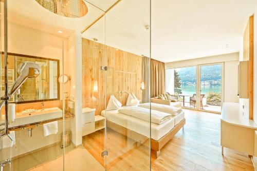 a bathroom with a bed and a shower and a sink at Amerika-Holzer Hotel & Resort in Sankt Kanzian