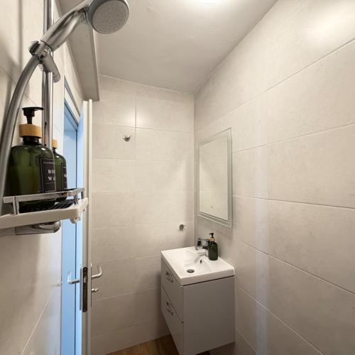 a white bathroom with a sink and a mirror at Cool Downtown Apartment in Burgas
