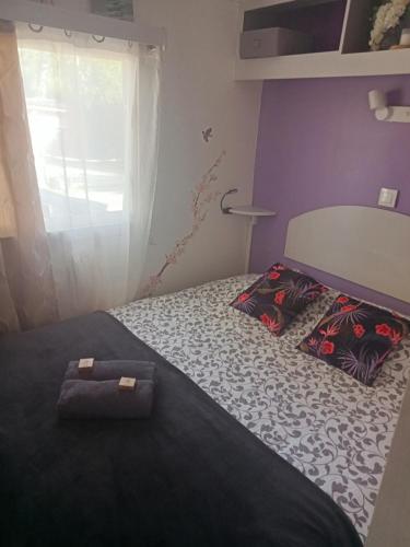 a bedroom with a bed with two pillows on it at Mobil home zen élégant in Mimizan
