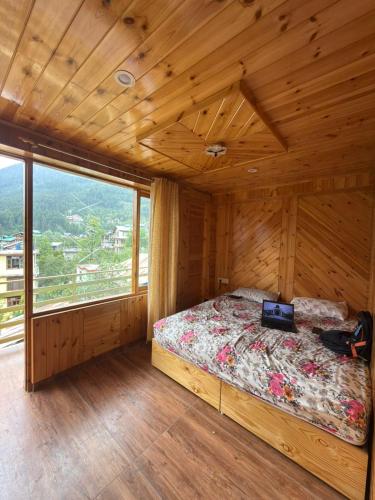 a bedroom with a bed in a wooden cabin at Nirvana Stays and Cafe in Manāli