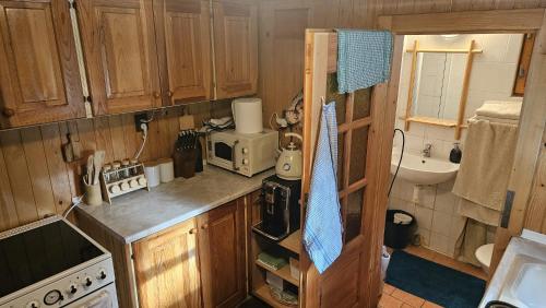 a kitchen with wooden cabinets and a counter top at Chata Bambi, Tatranská Štrba pri zubačke in Štrba
