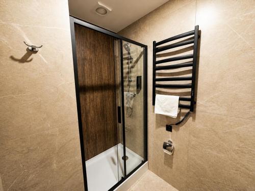 a shower in a bathroom with a glass shower backdoor at Prime Hotel in Dnipro