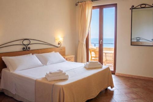 a bedroom with a bed with towels on it at Hotel Villa Gustui Maris in Cala Gonone