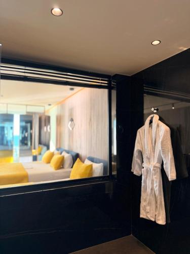 a room with a bed and a robe hanging on a wall at Esbjerg Hotel in Vlorë