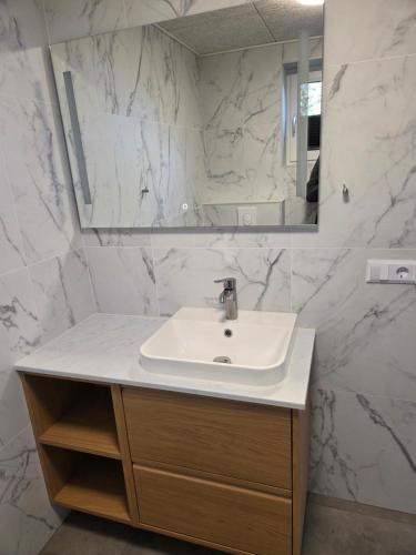 a white bathroom with a sink and a mirror at Harknakvej 19BB in Bredebro