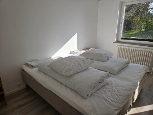 a bed with two pillows on it in a bedroom at Harknakvej 19BB in Bredebro