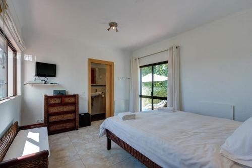 a bedroom with a large bed and a window at Casa Fole in Boliqueime
