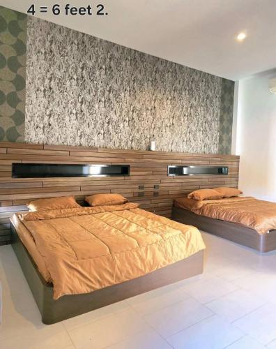 two beds in a bedroom with at Tiki Pool Pattaya in Ban Nong Pla Lai