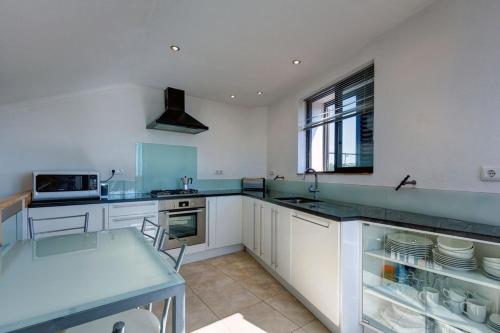 a kitchen with white cabinets and a blue counter top at Casa Fole in Boliqueime