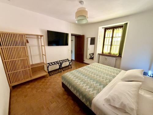 a bedroom with a bed and a television in it at Porta Del Ricetto in Candelo