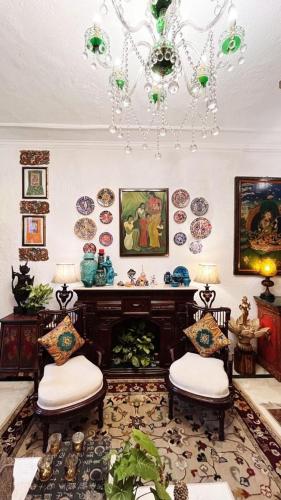 a living room with two chairs and a fireplace at On the House homestay in New Delhi