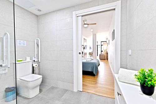 a bathroom with a toilet and a bedroom at Pato - Modern Apt - Near Bioparc by Río Turia Apartments in Valencia