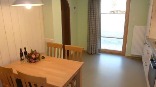 a dining room table with a vase of flowers on it at Ferienwohnung Hörnle Bad Kohlgrub in Bad Kohlgrub