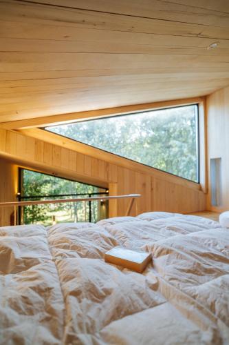 a large bed in a room with a window at The Grit - Adults-Only Modern Design House near Brașov in Vama Buzăului
