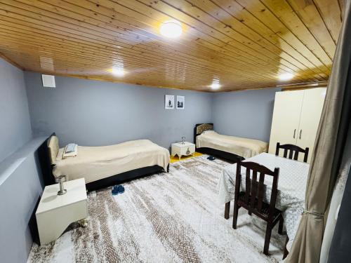 a room with two beds and a wooden ceiling at The House 39 in Sheki