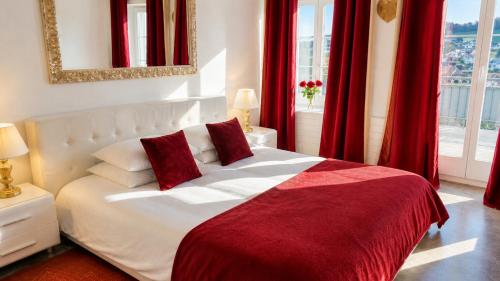a bedroom with a white bed with red curtains at AjoieSpa in Porrentruy