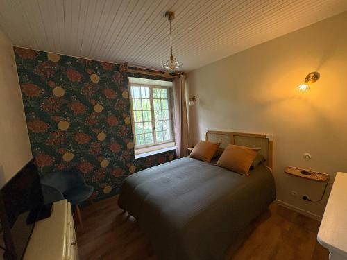a bedroom with a bed in a room with a window at La Roseraie de Malpas in Quingey