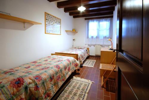 ヴィゴンツァにあるAgriturismo Villa Selvaticoのベッド2台とドレッサーが備わる客室です。