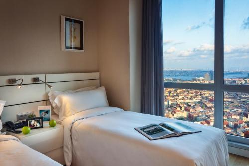 a hotel room with a bed and a large window at Fraser Place Anthill Istanbul in Istanbul