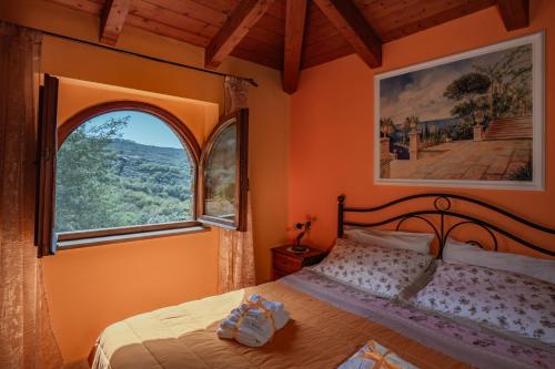 a bedroom with a bed and a large window at Villa Nigro in Laureana Cilento