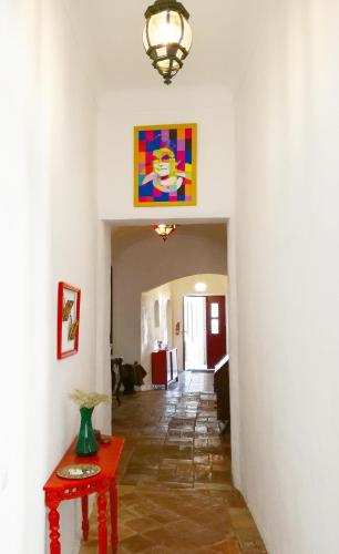 a hallway with a table and a painting on the wall at Casa da Avó Nina in Fuzeta