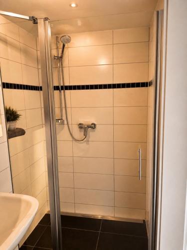 a bathroom with a shower with a tub and a sink at Ferienhaus Pfefferminzhütte in Mildenau