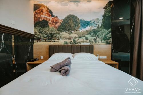 a bedroom with a large bed with a painting on the wall at IPOH AVS HOTEL by VERVE in Ipoh