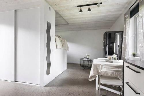 a white bathroom with a table and a mirror at Comfy Modern Guesthouse in Bankeryd