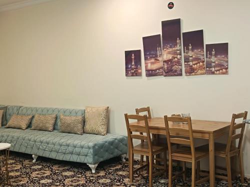a living room with a couch and a table with chairs at شقة العقيق الأولى in Medina