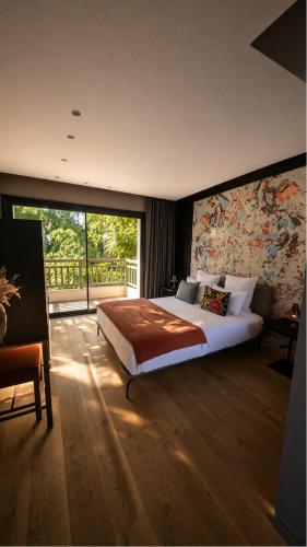 a bedroom with a large bed and a large window at Les Villas de la Ville d'Hiver Palissy et Velleda in Arcachon
