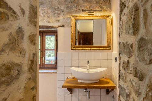 a bathroom with a sink and a mirror at Casale Santa Francesca by PosarelliVillas in Campiglia dʼOrcia