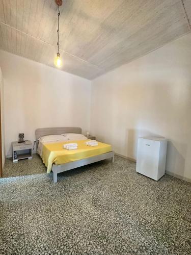 a bedroom with a yellow bed in a room at Camera Ficus in San Teodoro