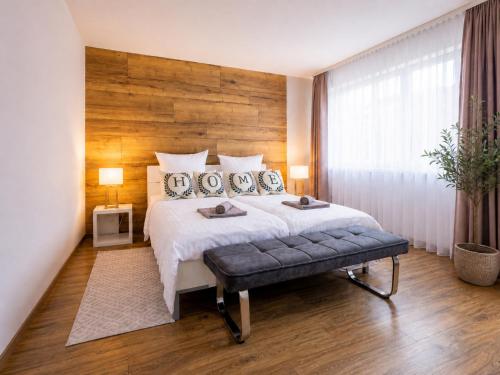a bedroom with a large bed with a wooden wall at Gelbe Koffer - Design-Apartment in Schiffweiler - 2 Parkplätze - Self-Check-in - ruhig & naturnah in Schiffweiler