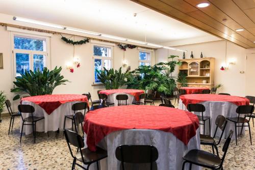 une salle avec des tables, des chaises et des plantes dans l'établissement Centro della Famiglia, à Trévise