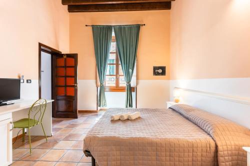 a bedroom with a bed and a desk and a television at Via Roma Rooms Guesthouse in Sassari