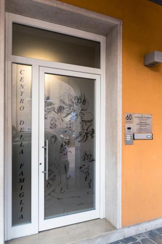 une porte en verre d'un bâtiment avec graffiti dans l'établissement Centro della Famiglia, à Trévise