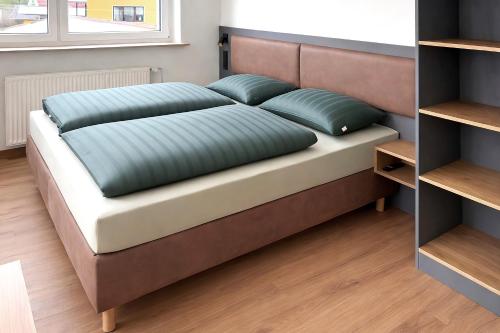 ein Bett mit zwei Kissen darauf in einem Zimmer in der Unterkunft Kleiner Wolf in Wachau