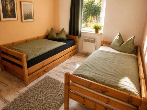 two twin beds in a room with a window at Ferienhaus Rauschenbachmühle in Arnsfeld