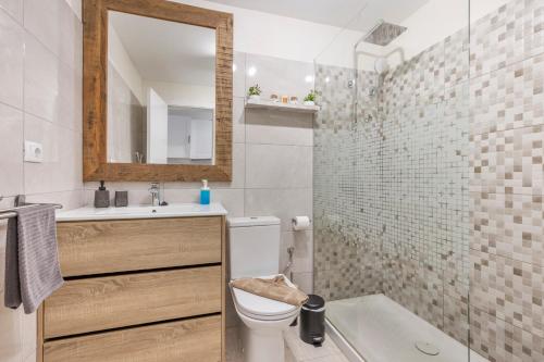 a bathroom with a toilet and a sink and a mirror at Casa Eri con piscina in Corralejo