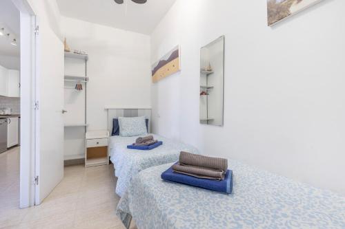 a bedroom with two beds and a mirror at Casa Eri con piscina in Corralejo